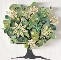 a tree made out of green paper with white flowers on it's leaves and swirls