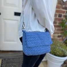 a woman carrying a blue crocheted purse