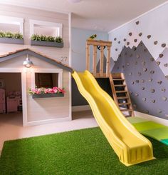 a child's playroom with a slide, climbing wall and flower boxes on the walls