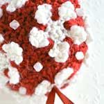 a crocheted red and white flower arrangement