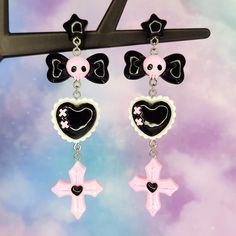 "Pastel goth earrings- fun cute cartoon earrings - skull bow cross heart - statement earrings - Japanese street fashion earrings Fun kawaii earrings perfect for the pastel goth lover! Stay stylish in these black and pink goth style earrings. 12mm wide plastic and silicone rubber backings included for comfort **Stainless steel earring posts are hypoallergenic and nickel free Made of resin / plastic Charms are one sided and flat on the back Earring length is: 3 5/8\" (in) Earring width is: 1\" (in Pink Goth Jewelry, Cute Goth Earrings, Kawaii Goth Accessories, Harajuku Style Black Jewelry, Black Emo Earrings For Gift, Black Harajuku Style Jewelry Gift, Harajuku Style Halloween Jewelry Gift, Emo Halloween Pierced Earrings, Halloween Emo Pierced Earrings