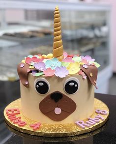 a decorated cake with a dog face and unicorn horn