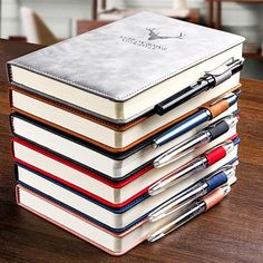 a stack of books with pens and notebooks sitting on top of eachother