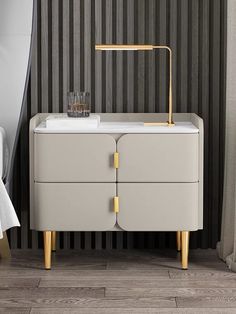 a white and gold sideboard next to a bed