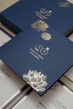 three blue and gold wedding cards on top of each other