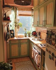 a small kitchen with green cabinets and wood flooring is pictured in this image from the doorway