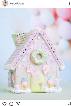 a pink and white gingerbread house with candy toppings on it's roof