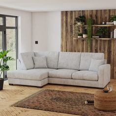 a living room with a couch, rug and potted plants