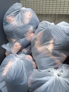 several bags of garbage are piled on top of each other