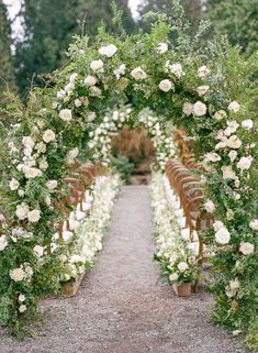 an outdoor ceremony with white flowers and greenery