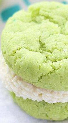 three cookies with green and white frosting stacked on top of each other