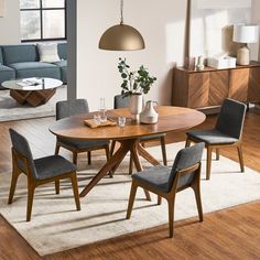 a dining room table with chairs and a rug on the floor