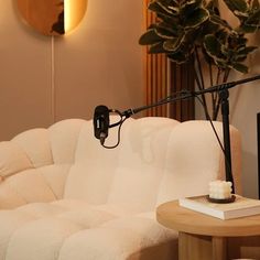 a living room with a white couch and a black lamp on the table next to it