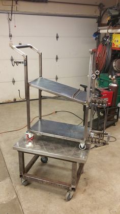 three metal shelves in a garage with tools on the top and one shelf above them