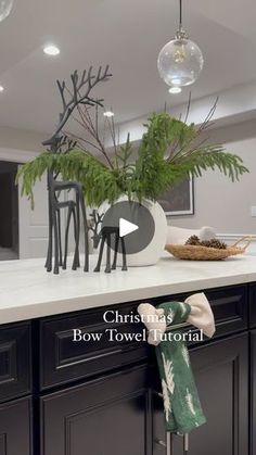 a kitchen with black cabinets and white countertops has a christmas tree in the center