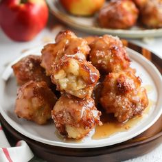 some food is sitting on a plate with apples in the background and another plate behind it