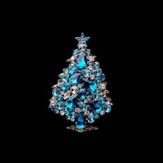 a blue christmas tree brooch sitting on top of a table