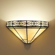 a wall light that is on the side of a wall with a glass shade over it