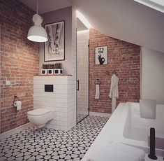 a bathroom with brick walls and white fixtures