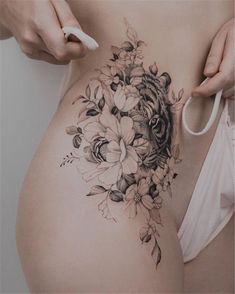 a woman's stomach with flowers on it and a stethoscope in her hand