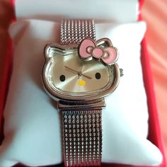 a hello kitty watch sitting on top of a pillow