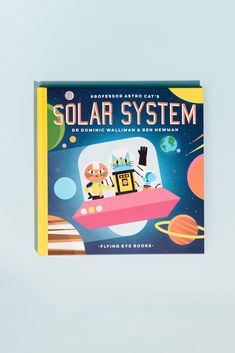 an illustrated book about the solar system on a white surface with space and planets in the background