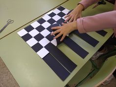 a woman is cutting out some black and white paper