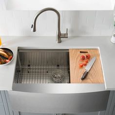 stainless steel kitchen sink with cutting board and knife