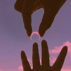 two hands reaching out towards each other with the sun in the sky behind them,