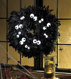 a halloween wreath with eyes on it sitting in front of a window