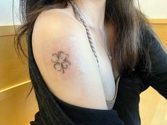 a woman with a four leaf clover tattoo on her shoulder