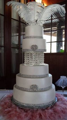 a white wedding cake with feathers on top