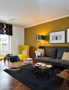 a living room filled with black furniture and yellow accents