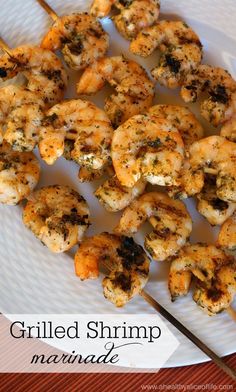 grilled shrimp marinade on a white plate with a wooden skewer next to it