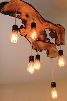 a chandelier made out of wood with light bulbs hanging from it