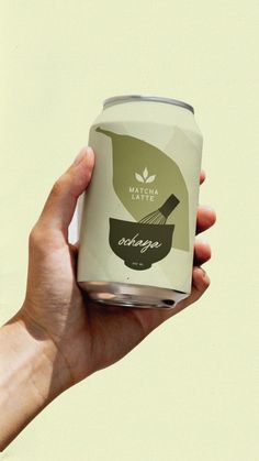 a hand holding a can of soup with a whisk on it's lid