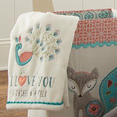 two towels hanging on the back of a chair with embroidered designs and words that say i love you here is you