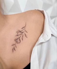 a woman's back with a tattoo on her left shoulder and an arrow in the middle