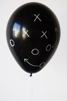 a black balloon with white numbers and faces drawn on it