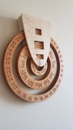 three wooden circles with numbers on them are hanging from the side of a white wall