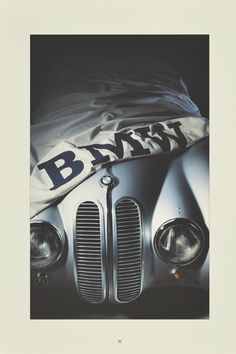 an old bmw car is covered with a white blanket and the word bmw on it