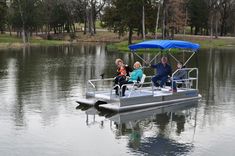 three people are sitting on a pontoon boat in the water with an umbrella over it