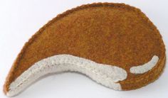 a close up of a brown and white hat on a white surface with one eye closed