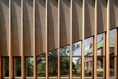 the exterior of a building with wooden slats on it's sides and large windows