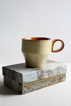 a coffee cup sitting on top of two books