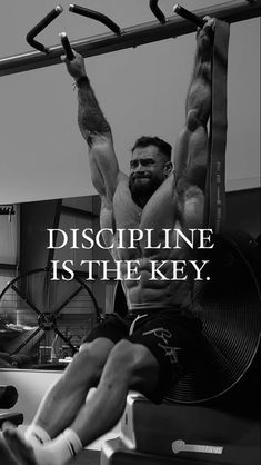 a man hanging upside down on a pull up bar with the words, discipline is the key