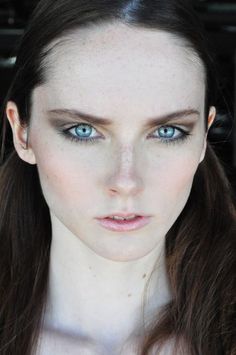 a woman with blue eyes and long brown hair