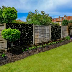 a wooden fence in the middle of a green yard