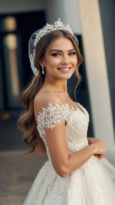 a woman in a wedding dress posing for the camera wearing a veil and tiara