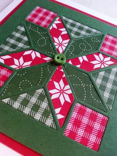 a green and red christmas card with a button on the center that has snowflakes